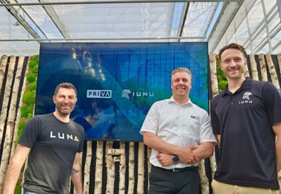 Group standing in front of a large screen showing the Priva and IUNU logos inside a greenhouse structure.